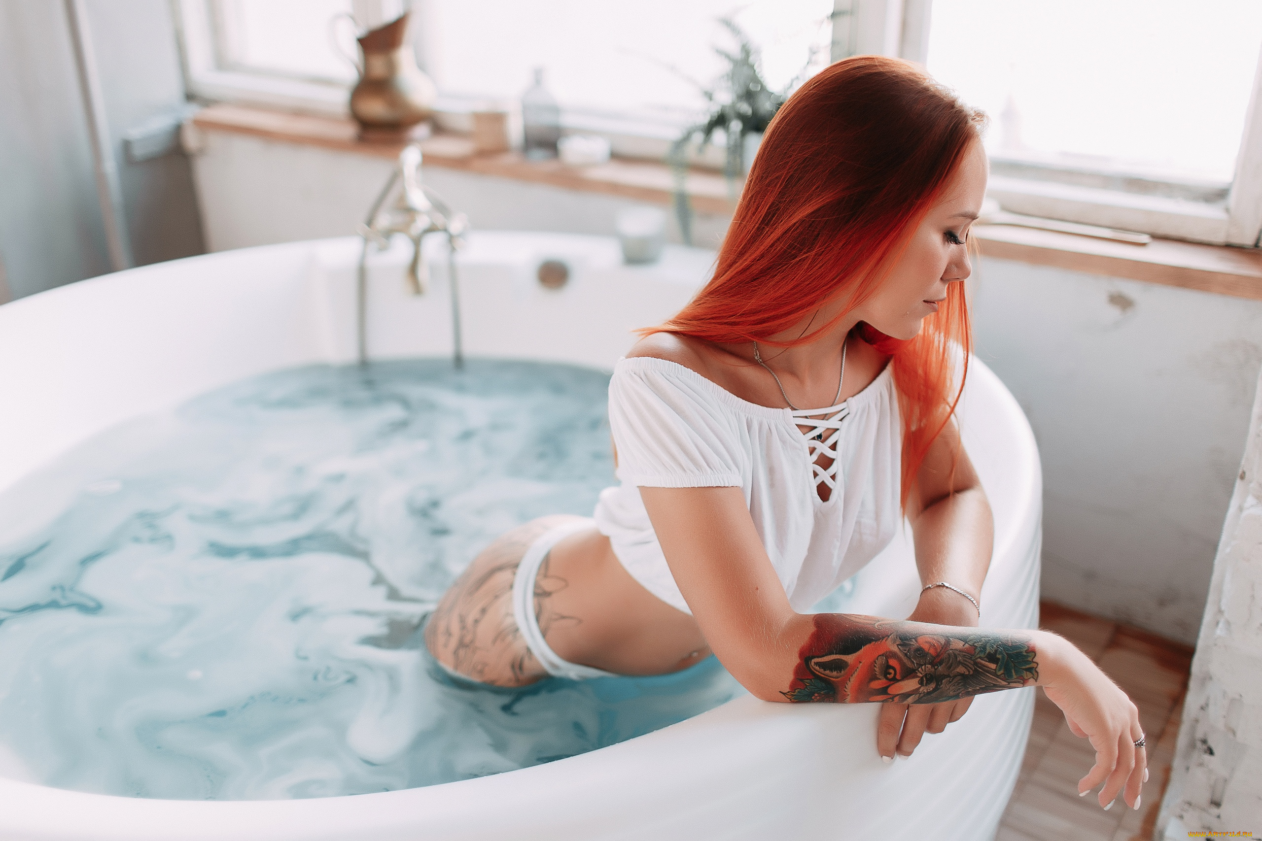 Худышка с длинными волосами обливается водой в ванне джакузи