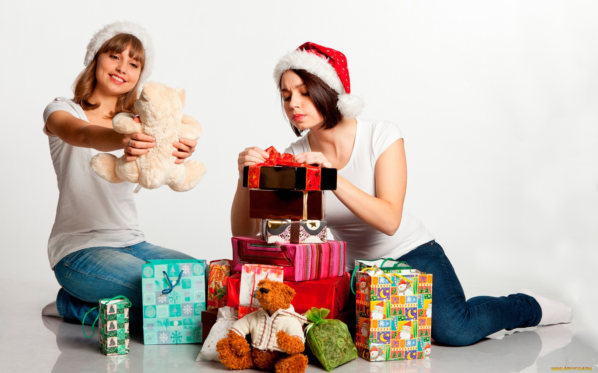 девушки, -unsort, , снегурочки, праздник, игрушки, шапки, на, полу, две, настроение, пакеты, майки, плюшевые, сидят, рождество, белый, фон, коробки, новый, год, подарки, джинсы, радость